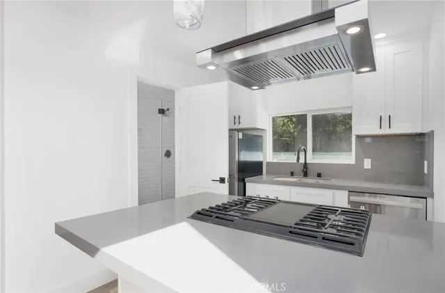 a kitchen with stainless steel appliances a refrigerator and a stove