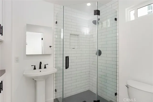 a bathroom with a sink a toilet and shower