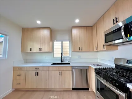 a kitchen with white cabinets sink and stainless steel appliances
