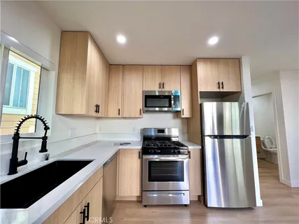a kitchen with a sink a refrigerator and cabinets