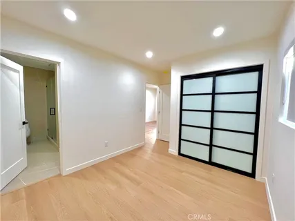 wooden floor in an empty room with a bathroom