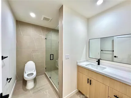 a bathroom with a toilet a sink and mirror