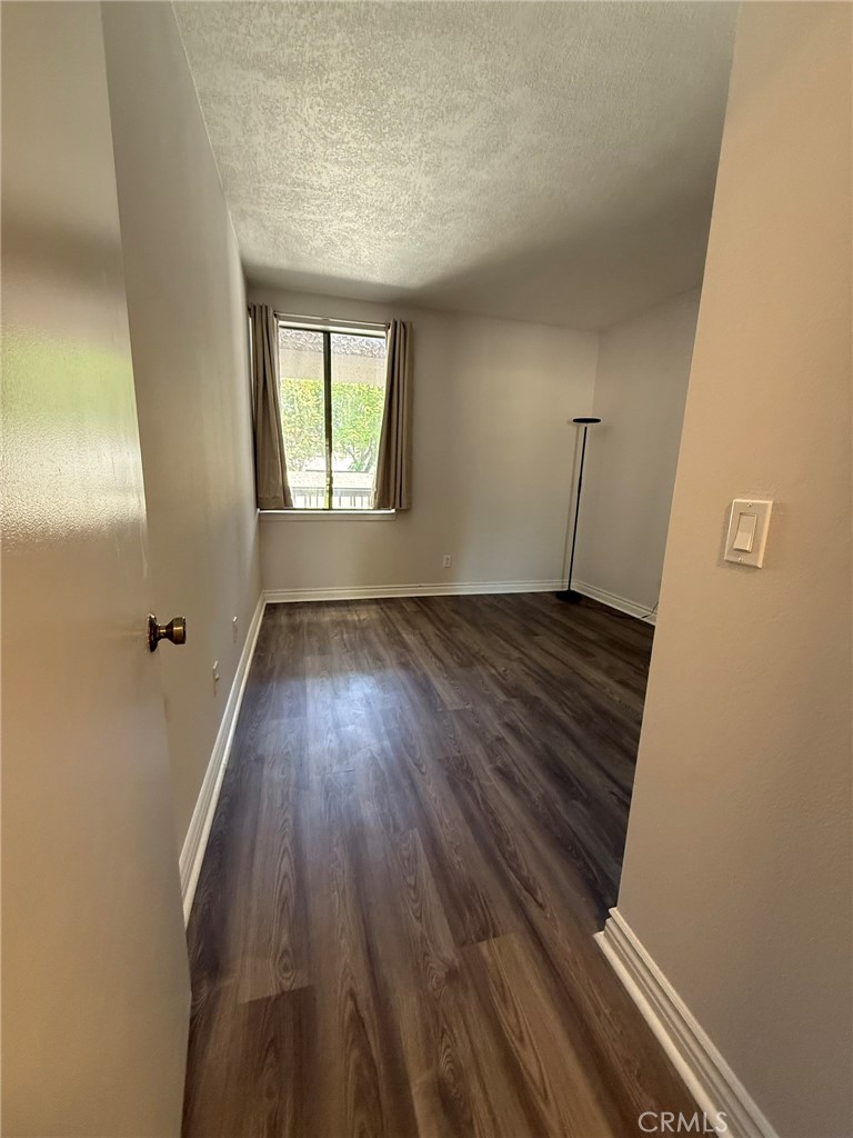 5555 Canyon Crest Drive, Unit 3B Riverside, CA 92507 - Photo 11 of 26 an empty room with wooden floor and windows
