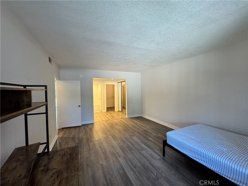 5555 Canyon Crest Drive, Unit 3B Riverside, CA 92507 - Photo 14 of 26 a view of an empty room and wooden floor