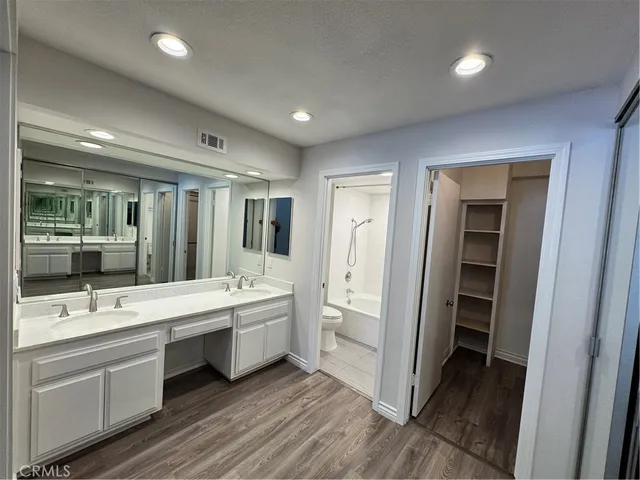 a bathroom with a double vanity sink mirror and bathtub