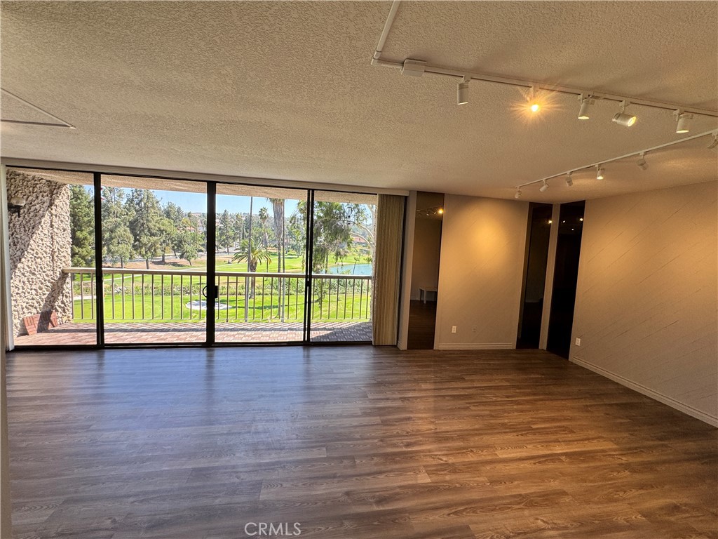 5555 Canyon Crest Drive, Unit 3B Riverside, CA 92507 - Photo 2 of 26 a view of an empty room with wooden floor and a window