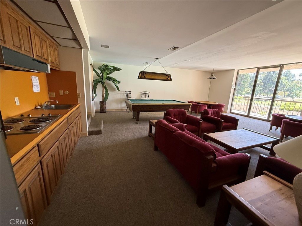 5555 Canyon Crest Drive, Unit 3B Riverside, CA 92507 - Photo 22 of 26 a living room with furniture and a flat screen tv