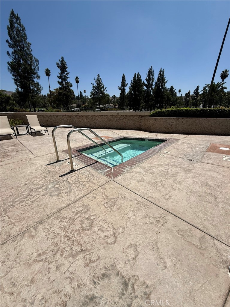 5555 Canyon Crest Drive, Unit 3B Riverside, CA 92507 - Photo 25 of 26 a view of swimming pool with outdoor seating and trees in the background