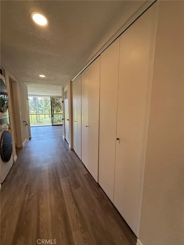 a view of a hallway with wooden floor and a sink