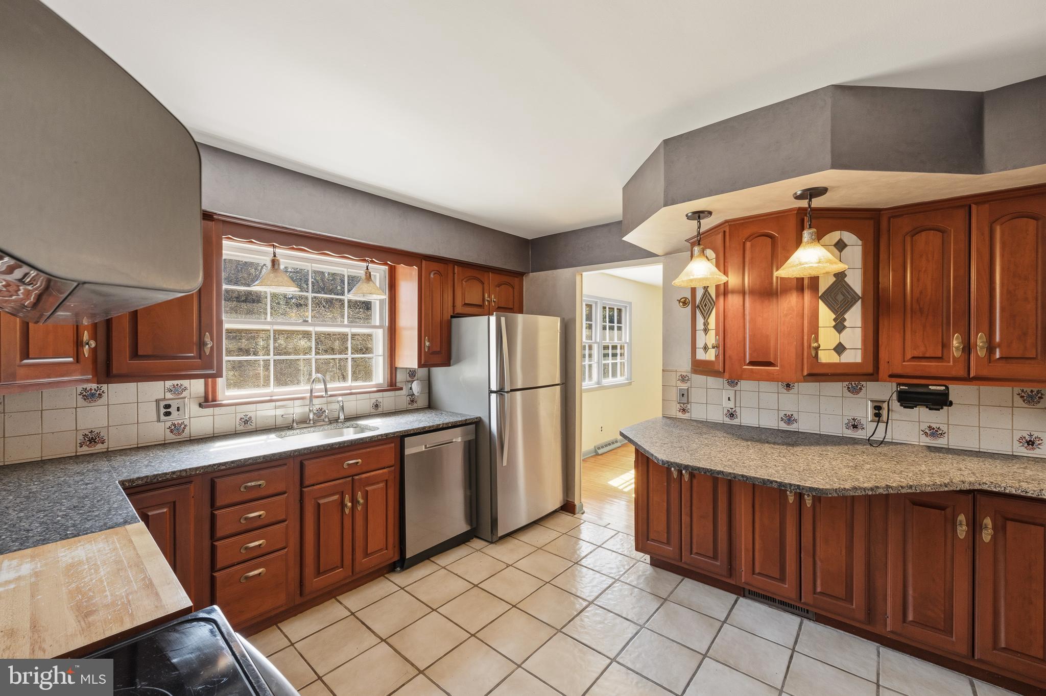 413 Columbia Avenue Pitman, NJ 08071 - Photo 11 of 33 a kitchen with stainless steel appliances granite countertop a sink and a refrigerator