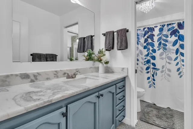 a bathroom with a granite countertop sink a mirror and shower