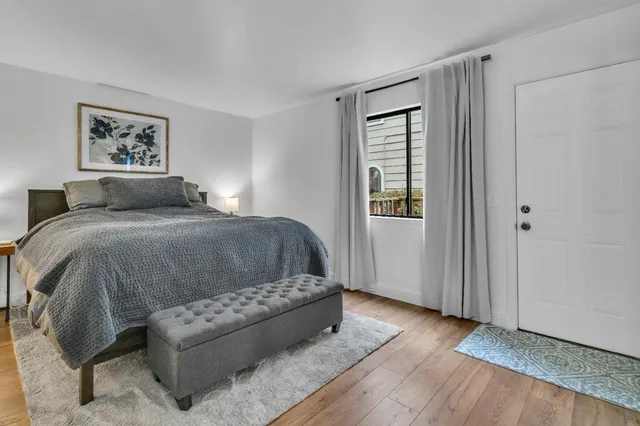 a bedroom with a bed couch and painting on the wall