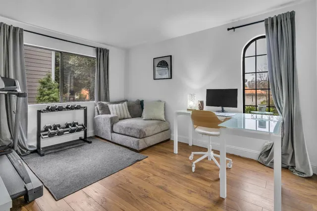 a living room with furniture a rug and a floor to ceiling window