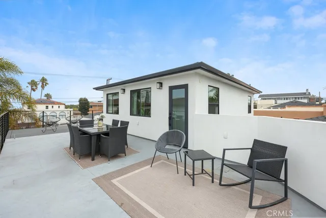 a view of a patio with couches table and chairs and potted plants