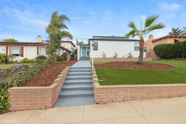 a view of a house with a yard and potted plants