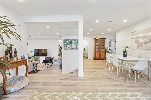 a living room with furniture a wooden floor and a view of kitchen