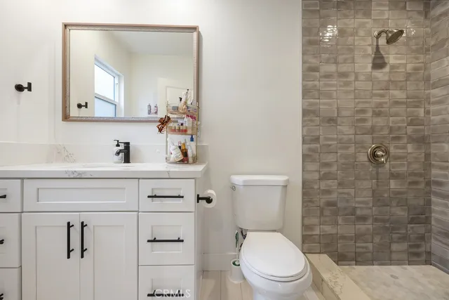 a bathroom with a toilet sink vanity and mirror
