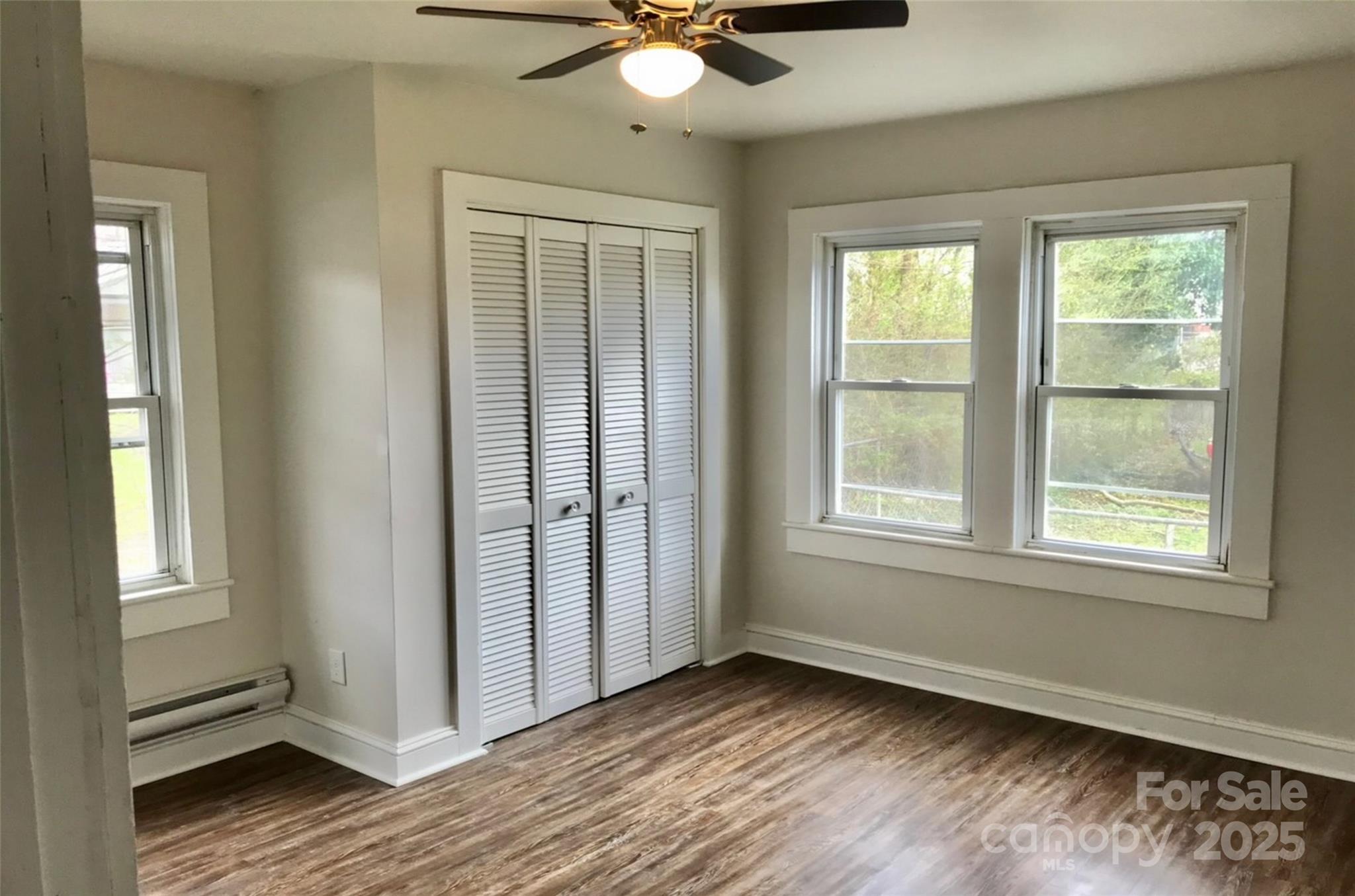 24 Timber Lane Waynesville, NC 28786 - Photo 10 of 13 an empty room with wooden floor fan and windows