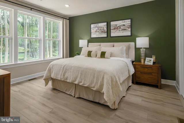 a bedroom with a bed wooden floor and window
