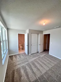 an empty room with windows and closet