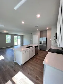 a kitchen with a sink and wooden floor