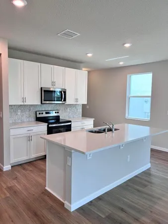 a kitchen with stainless steel appliances a sink a stove a microwave and cabinets