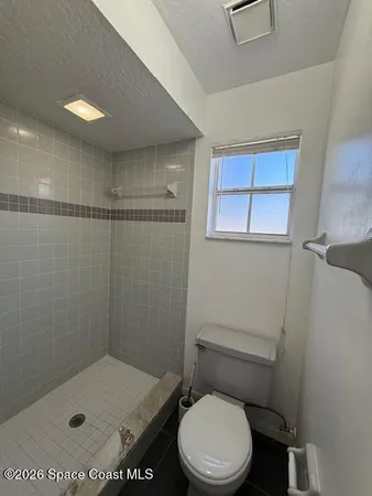 a bathroom with a toilet and a shower
