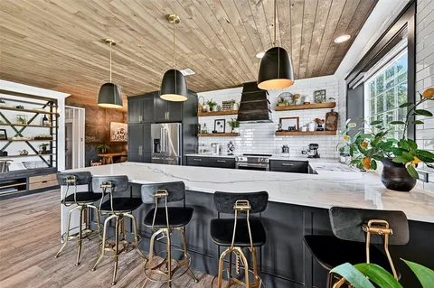 a kitchen with a dining table chairs and white cabinets