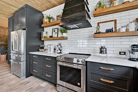 a kitchen with stainless steel appliances granite countertop a stove and a refrigerator