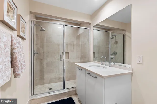 a bathroom with a shower sink and mirror