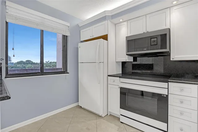 a kitchen with cabinets stainless steel appliances and a counter space