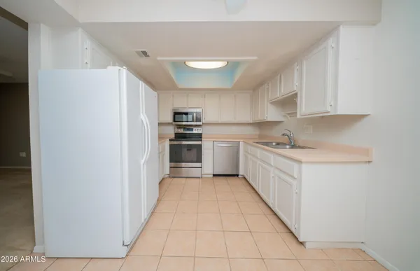 a kitchen with white cabinets and stainless steel appliances
