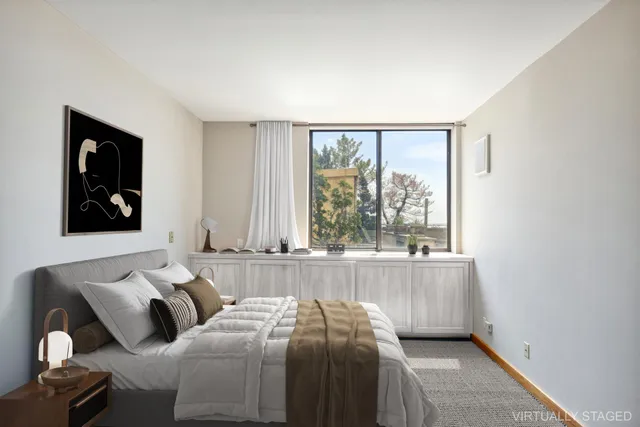 a bedroom with two beds and large window