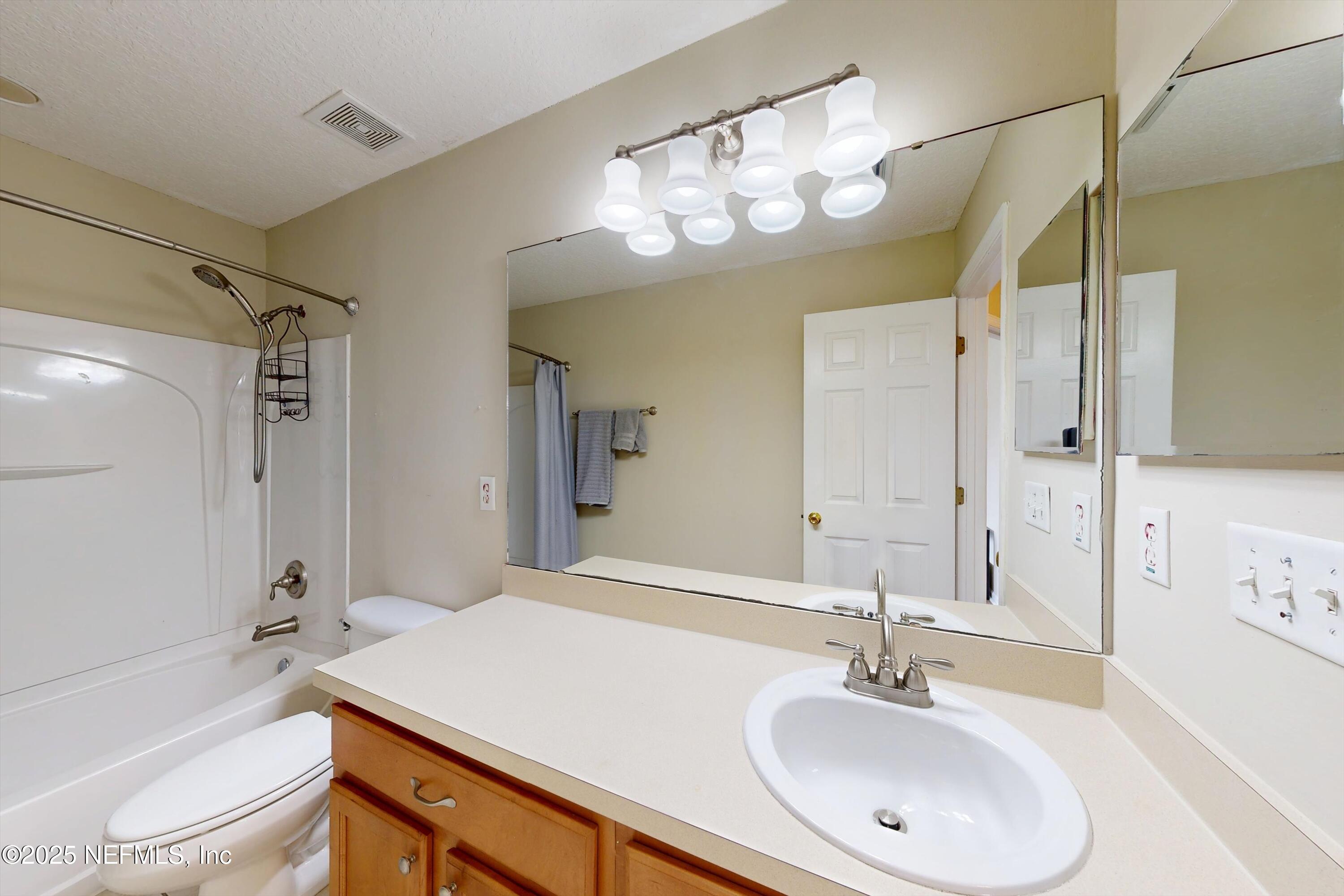 2360 Golfview Drive Fleming Island, FL 32003 - Photo 26 of 60 a bathroom with a sink a large mirror and a bathtub