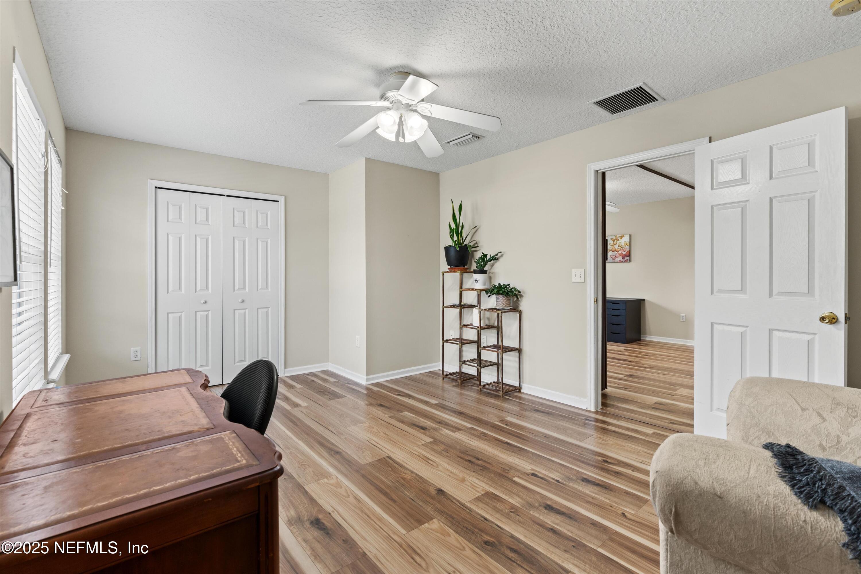 2360 Golfview Drive Fleming Island, FL 32003 - Photo 27 of 60 a bedroom with a bed and a chandelier