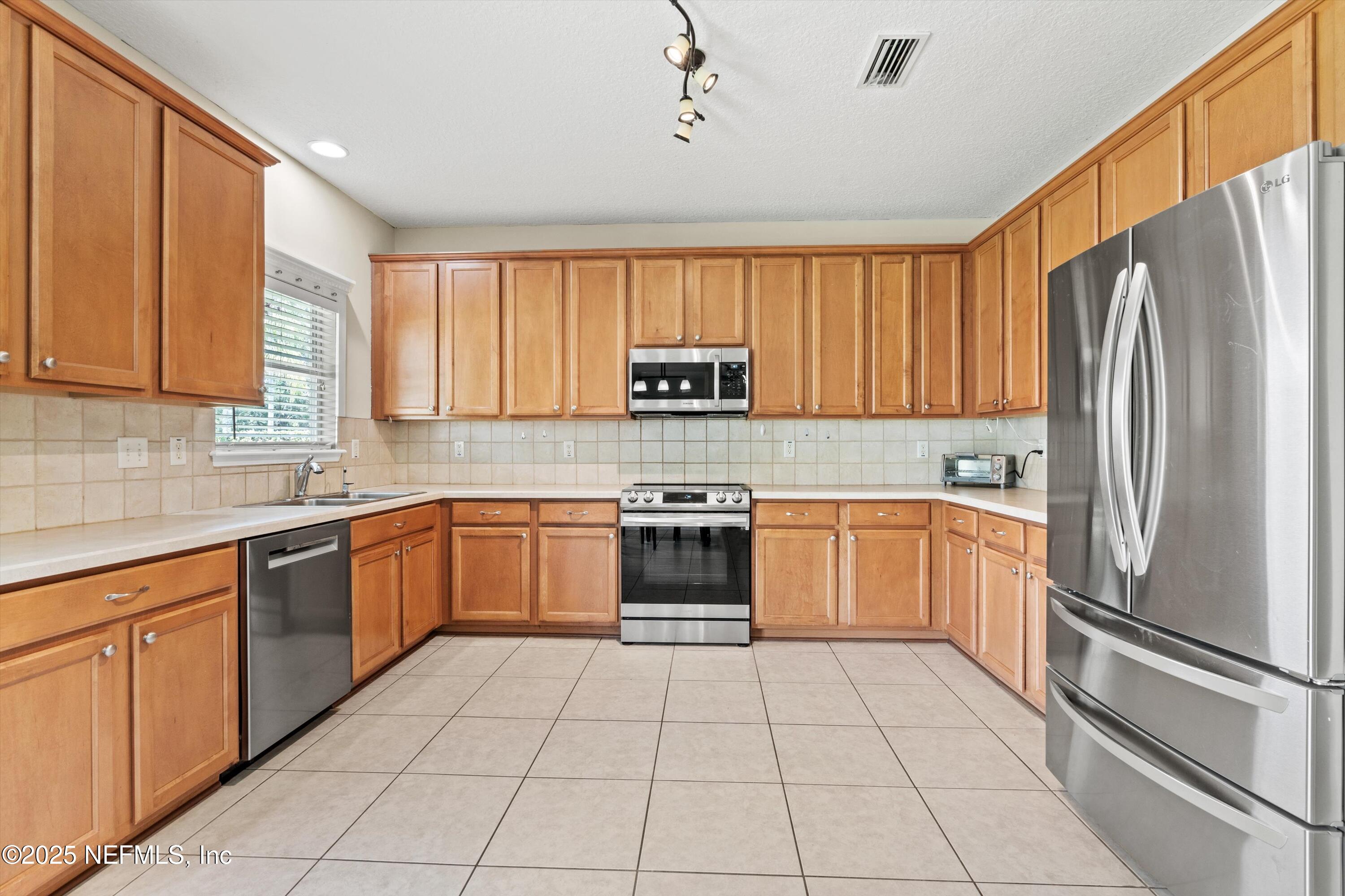 2360 Golfview Drive Fleming Island, FL 32003 - Photo 3 of 60 a kitchen with a refrigerator a stove top oven a sink and dishwasher