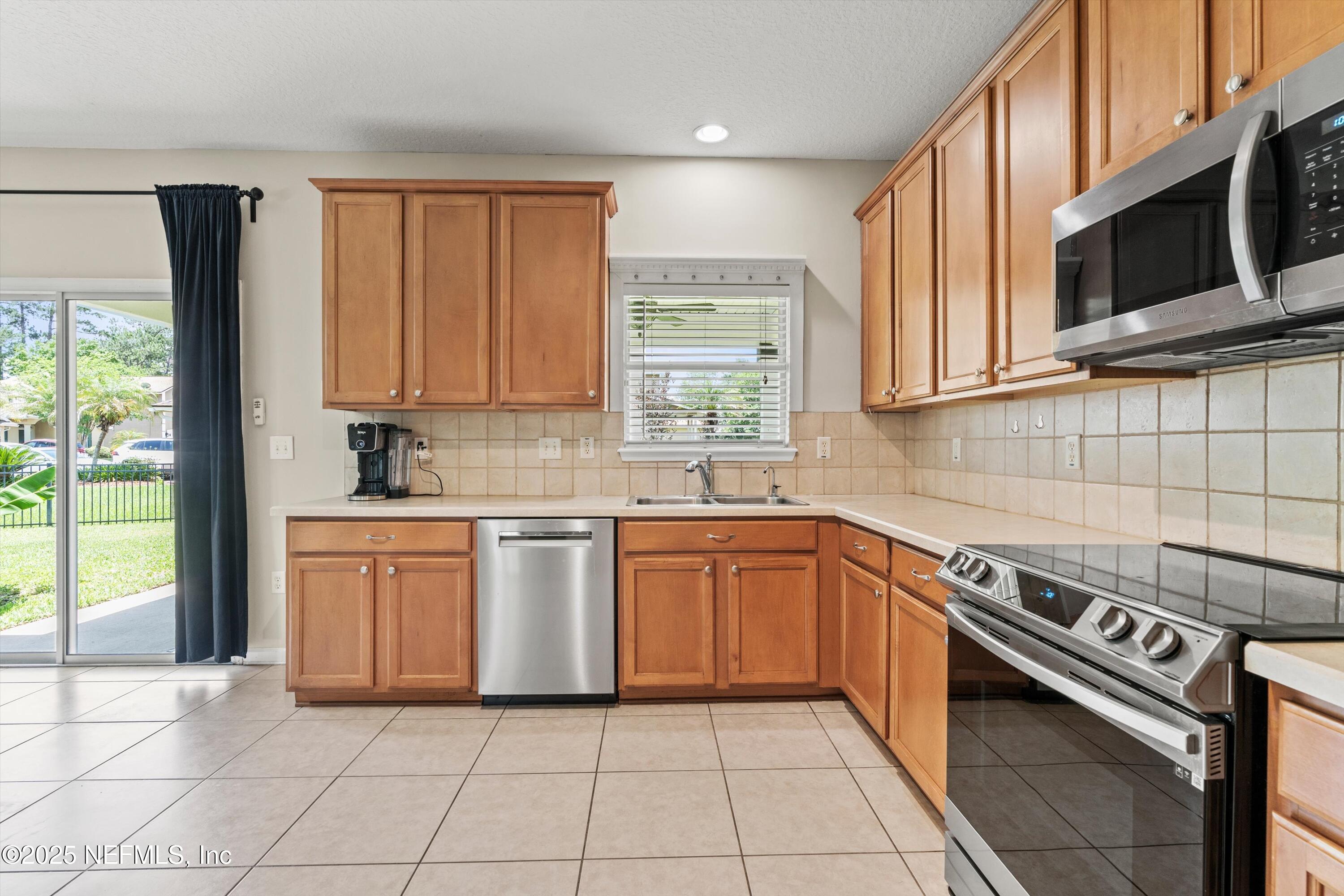 2360 Golfview Drive Fleming Island, FL 32003 - Photo 34 of 60 a kitchen with stainless steel appliances granite countertop a stove a sink and a microwave