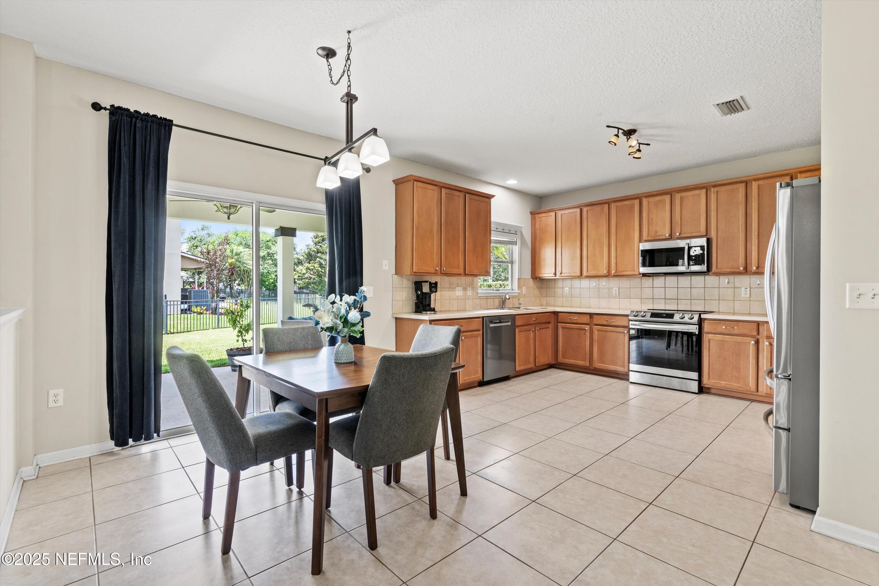 2360 Golfview Drive Fleming Island, FL 32003 - Photo 4 of 60 a kitchen with stainless steel appliances granite countertop a stove top oven a sink dishwasher a dining table and chairs