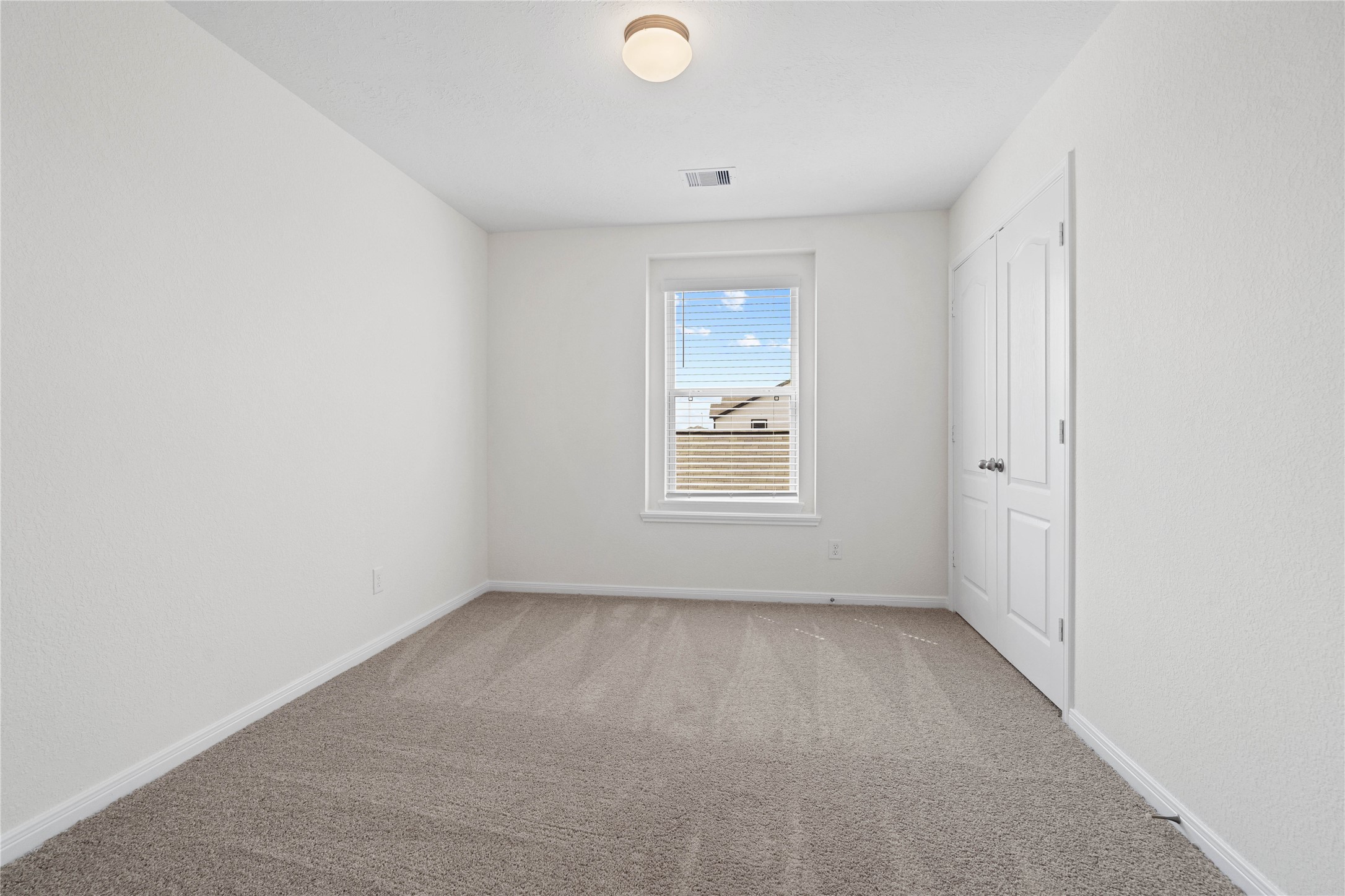 6418 Kentfield Drive Rosharon, TX 77583 - Photo 14 of 23 This secondary bedroom offers comfort and style with plush carpeting, neutral paint tones, globe lighting, a large window with blinds, and a generously sized closet.