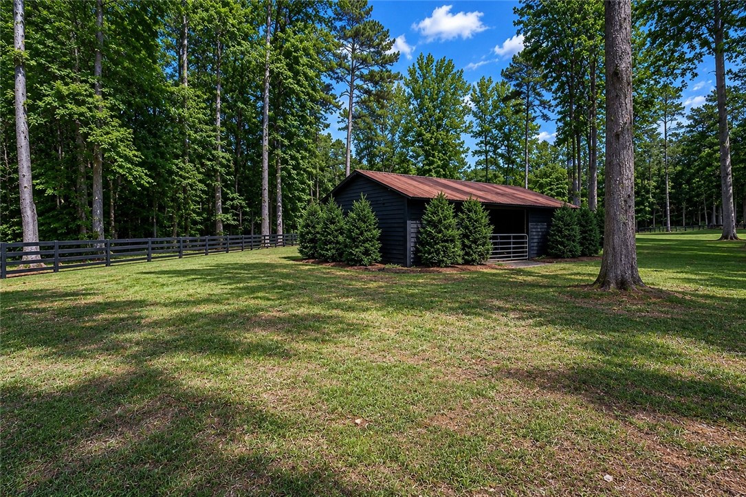 414 Devon Way Anderson, SC 29621 - Photo 44 of 50 A quaint barn structure nestles into the lush, tree-lined landscape, offering peaceful rural living.