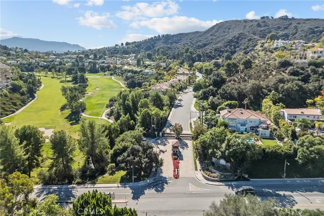 an aerial view of residential houses with outdoor space and trees