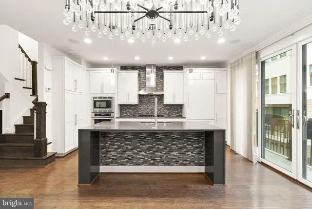 a large kitchen with stainless steel appliances kitchen island granite countertop a stove and a sink