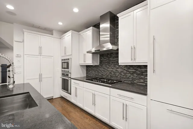 a kitchen with granite countertop white cabinets and a stove