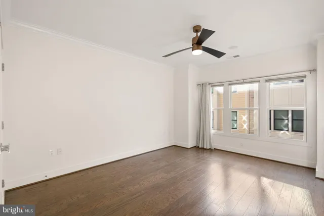 a view of a hallway with wooden floor and closet area