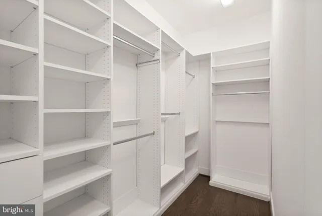 an empty room with windows and ceiling fan