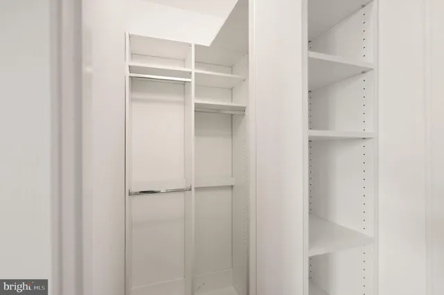 an empty room with wooden floor ceiling fan and window