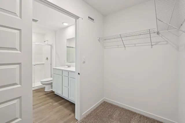 a bathroom with a granite countertop sink a toilet and a shower
