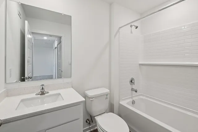 a bathroom with a sink toilet vanity and tub
