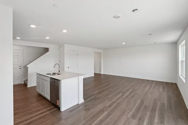 an empty room with wooden floor and entrance