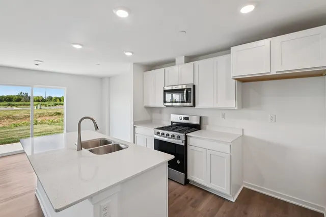 a kitchen with a sink a stove a microwave and cabinets